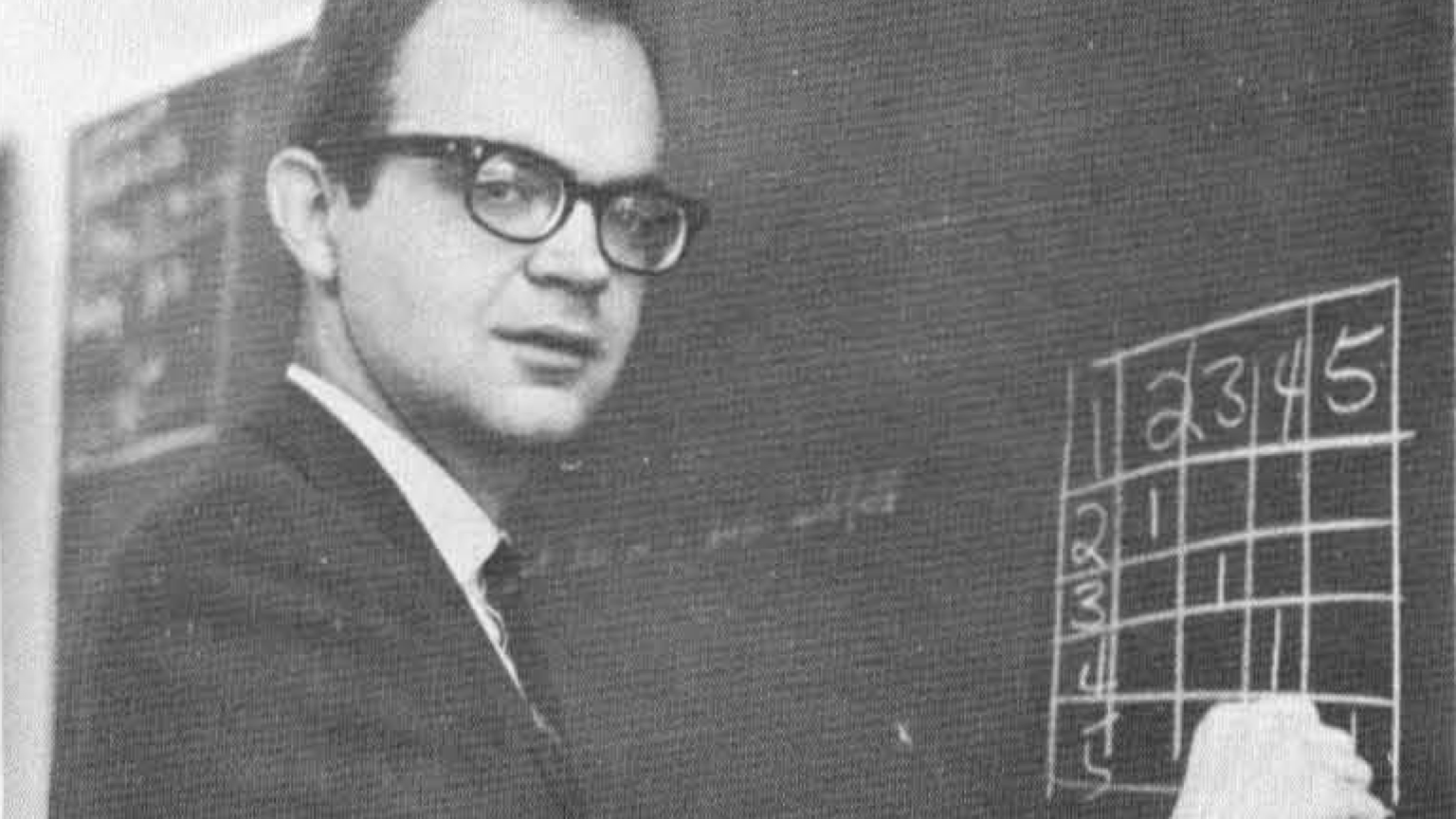 Donald Knuth à côté d’un tableau noir à Caltech en 1965.