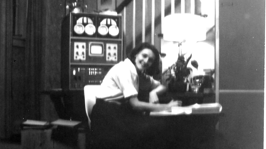 Mary Allen Wilkes seated at a table beside a LINC computer in her parents' home in 1965.