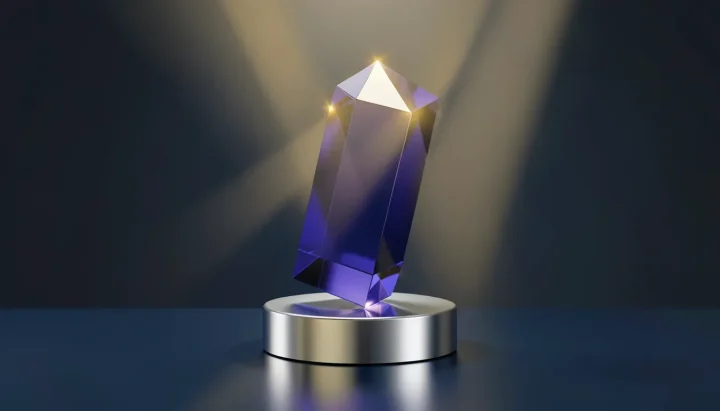 Ein vielflächiges, transparentes Glasprisma in Indigoblau steht auf einem silbernen Sockel, während goldene Lichtstrahlen gebrochen über eine dunkle Metalloberfläche verlaufen.