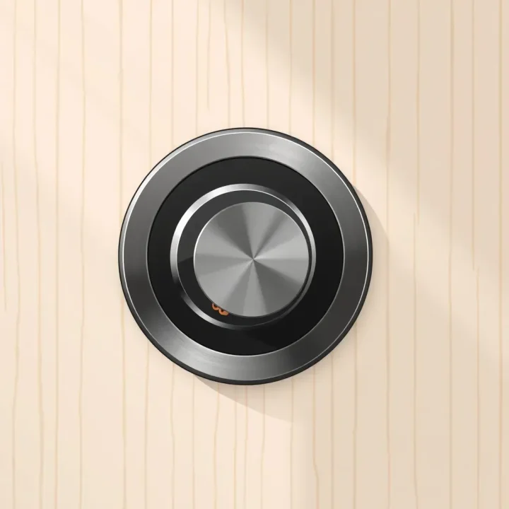 Redaktionelle Illustration eines kreisförmigen Smart Locks aus gebürstetem Edelstahl mit integriertem kinetischem Drehregler und dezent sichtbaren Kupferzahnrädern vor einer hellen Holzverkleidung.