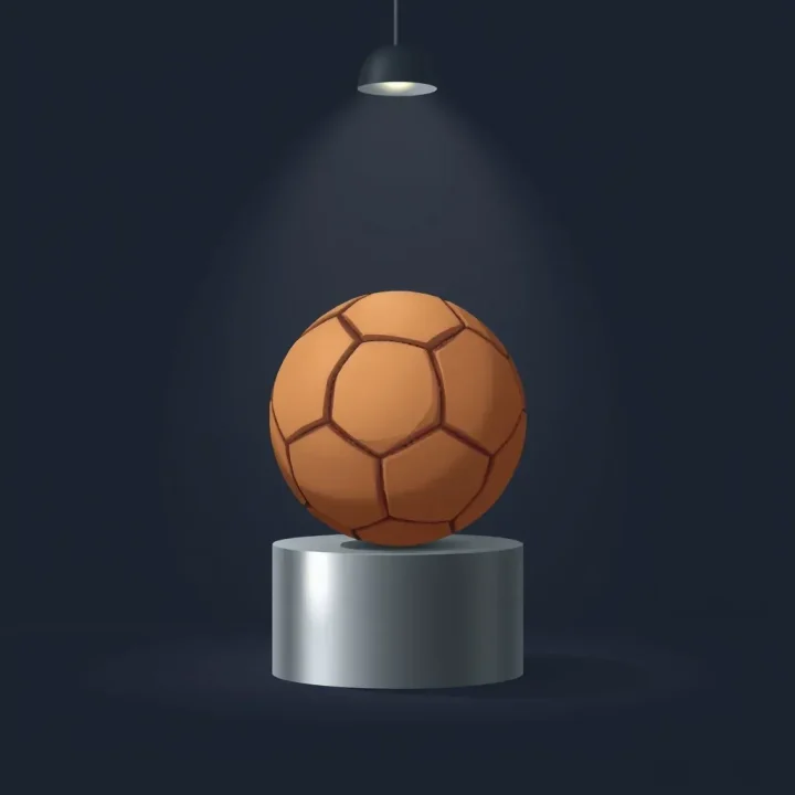 Un balón de fútbol de cuero desgastado sobre un pedestal de acero pulido bajo un único foco de luz.